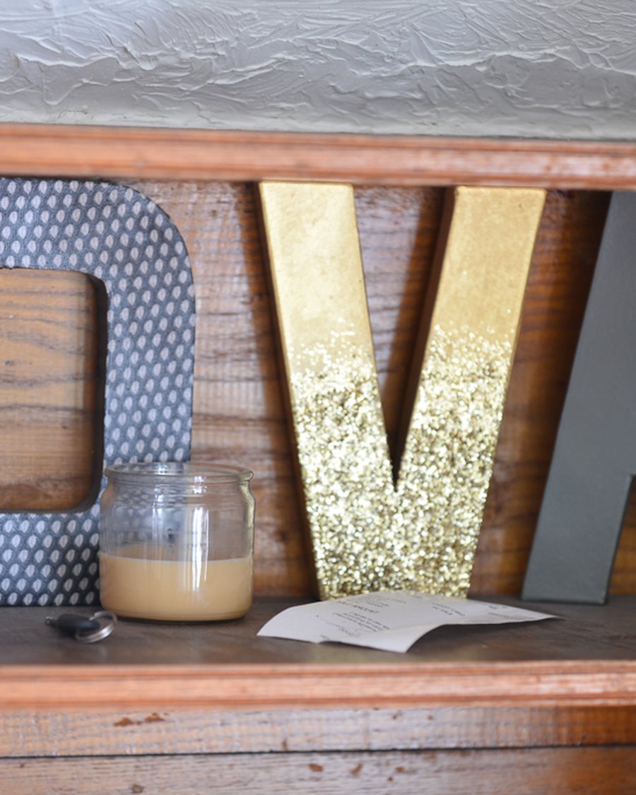 The gold D'Va lettering on a reclaimed-wood shelf in the salon