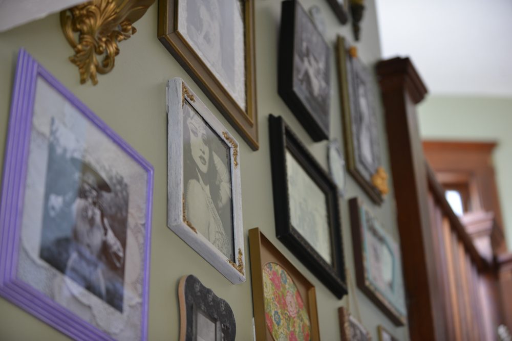 A wall of framed photographs in the historic house